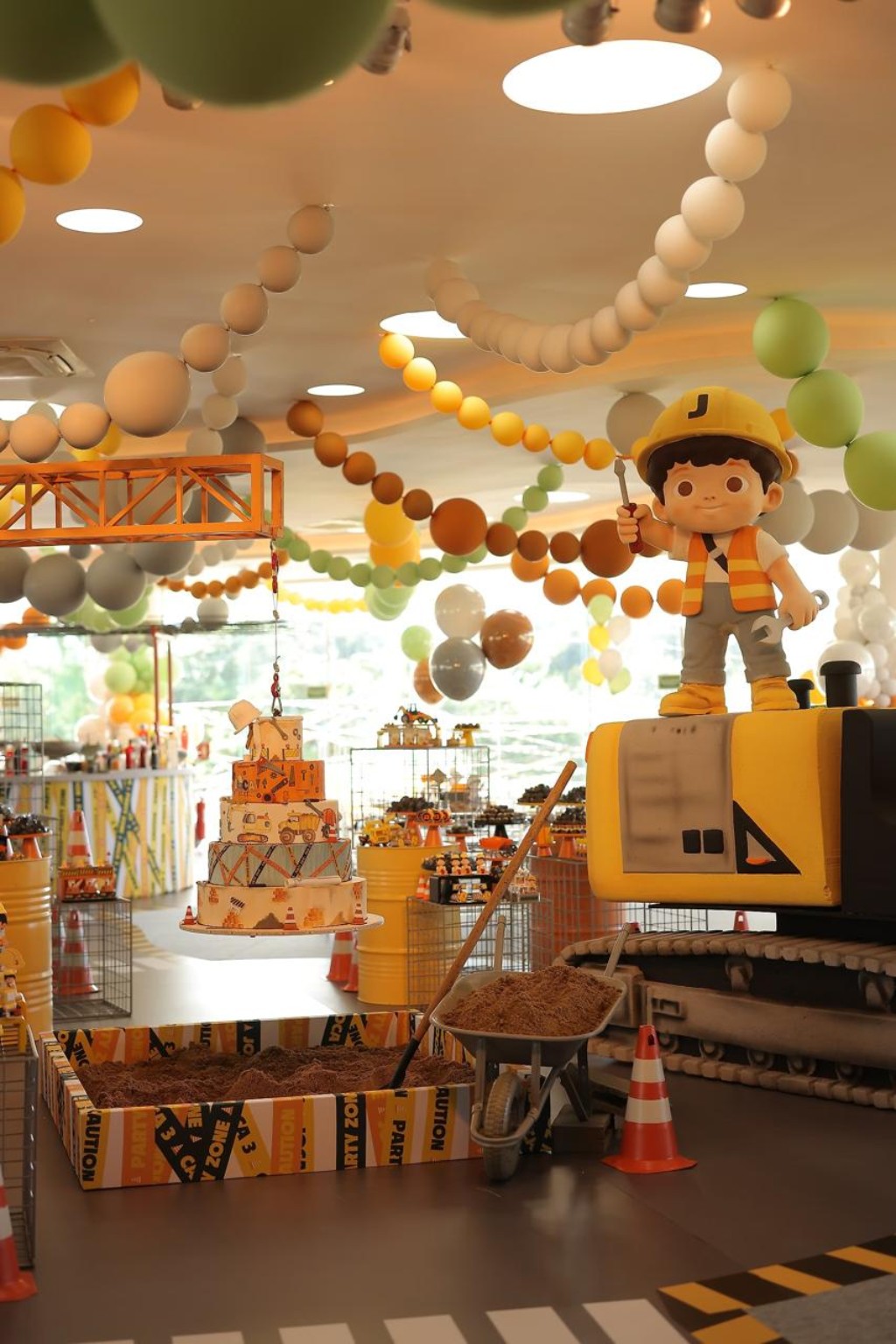 Festa infantil com tema de construção, máquina cenográfica e elementos de obra
