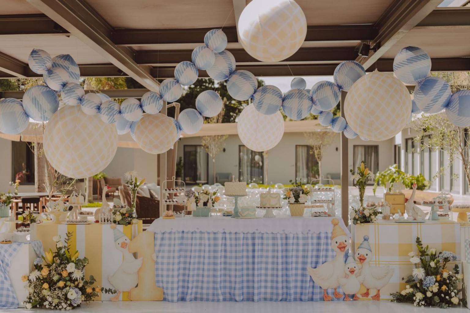 Decoração delicada em azul e amarelo com patinhos, flores e balões suspensos